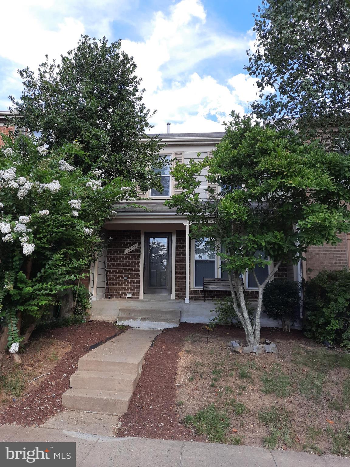 a front view of a house with a tree