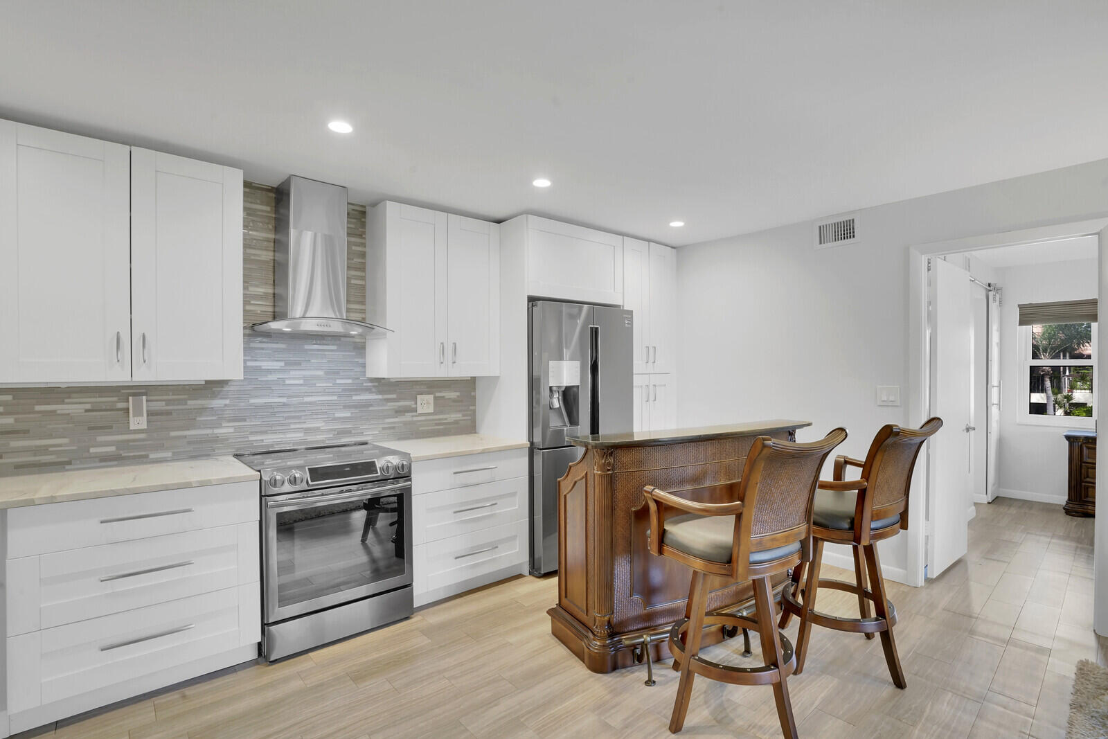 a view of kitchen with refrigerator stove and wooden floor