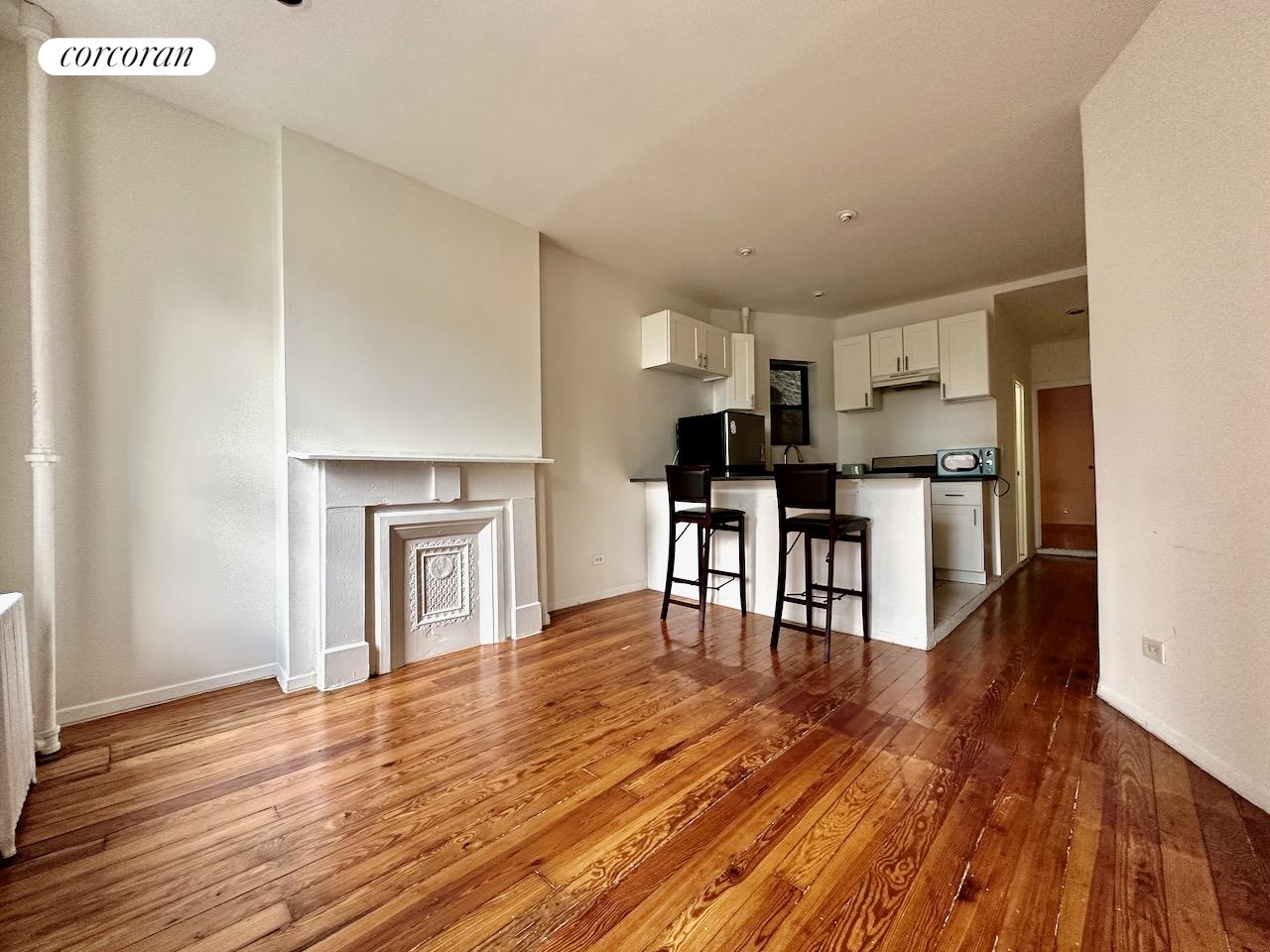 a view of kitchen with microwave and wooden floor