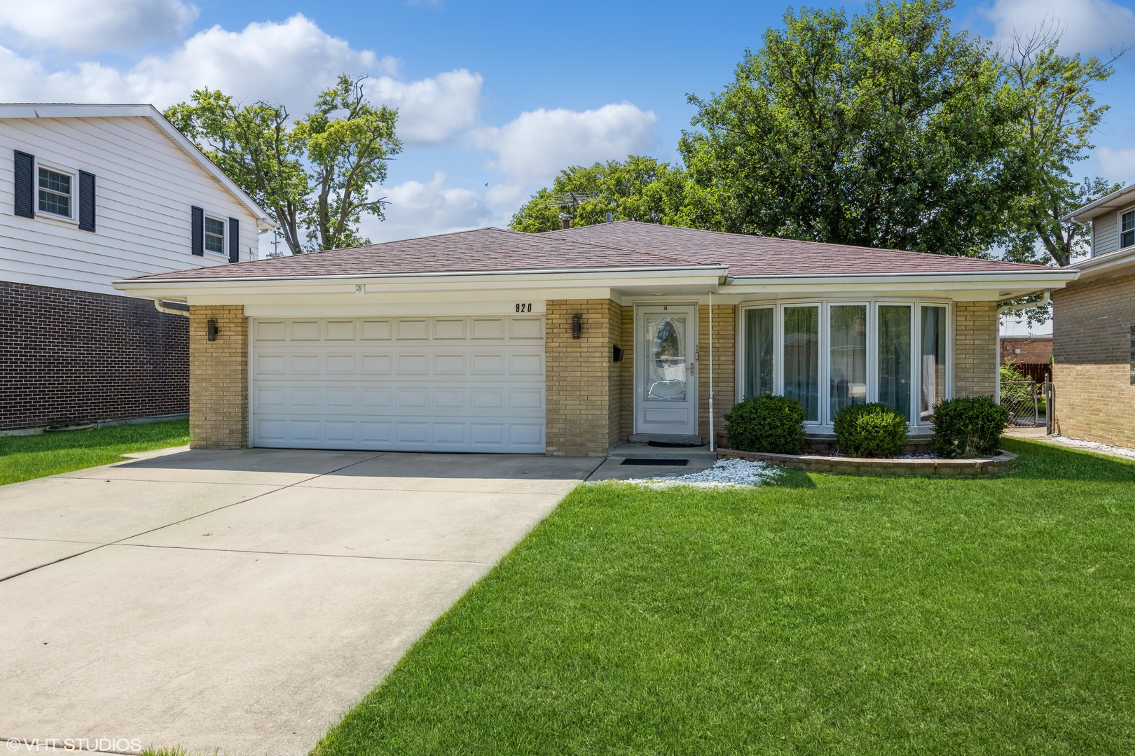 a front view of a house with a garden and yard