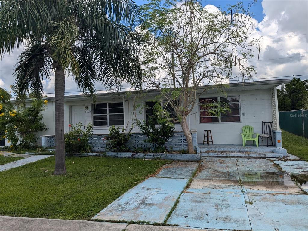 a front view of a house with a yard and potted plants