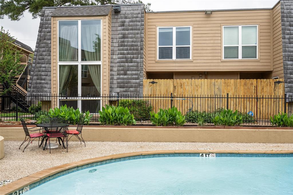 a patio with a table and chairs and potted plants