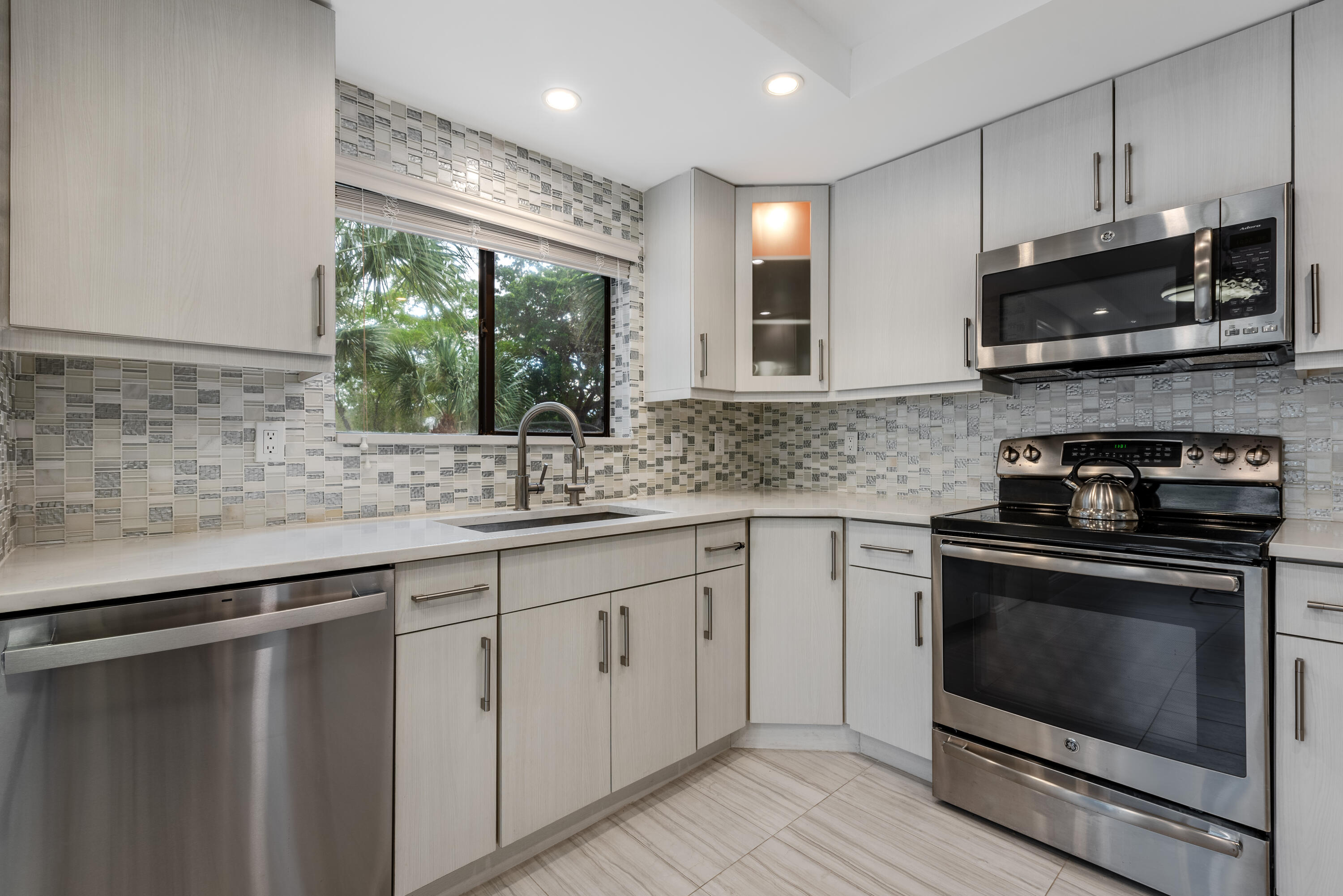 a kitchen with stainless steel appliances white cabinets a sink and a stove