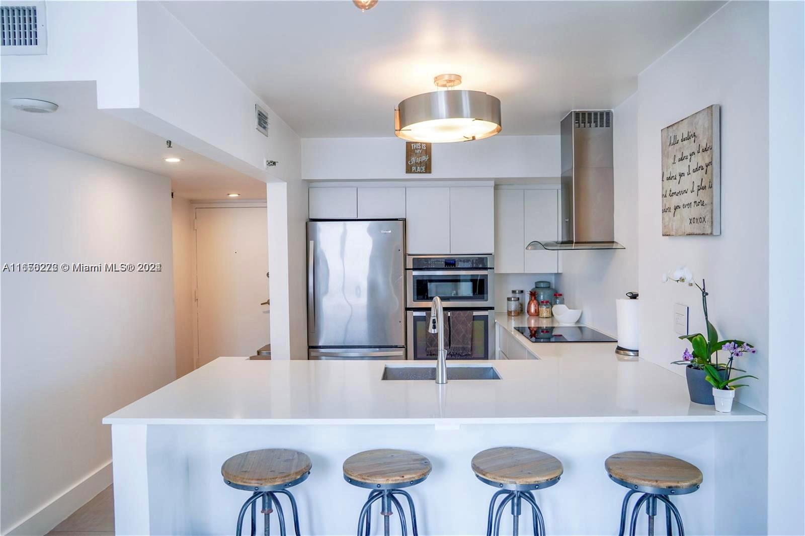 a kitchen with stainless steel appliances a table chairs and refrigerator