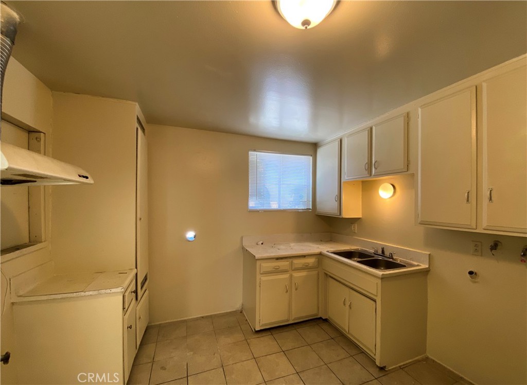 a kitchen with a sink a refrigerator and cabinets