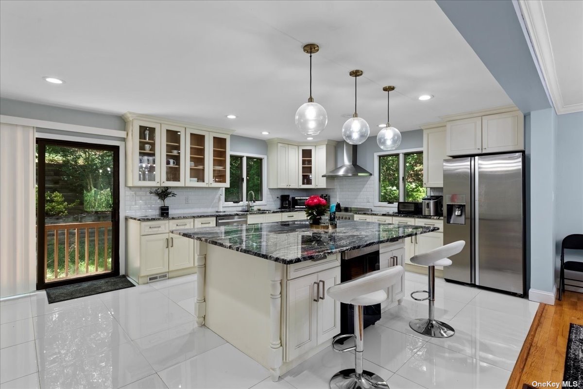 a kitchen with kitchen island granite countertop a large center island a stove and a refrigerator