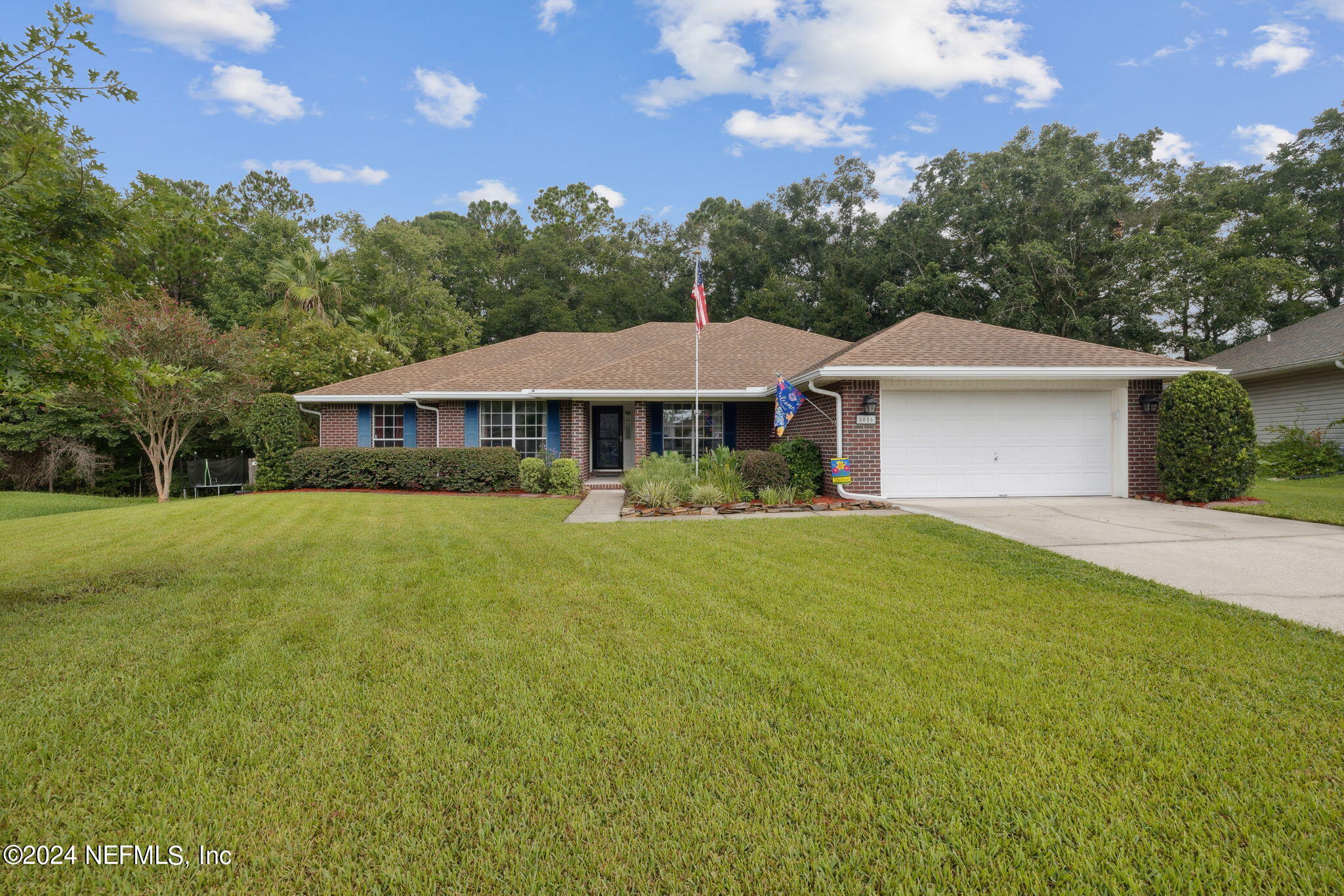 a front view of a house with yard and green space