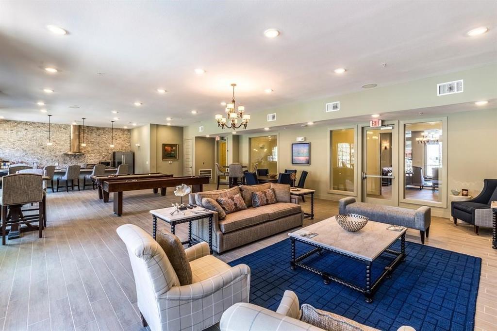 a living room with furniture kitchen view and a wooden floor