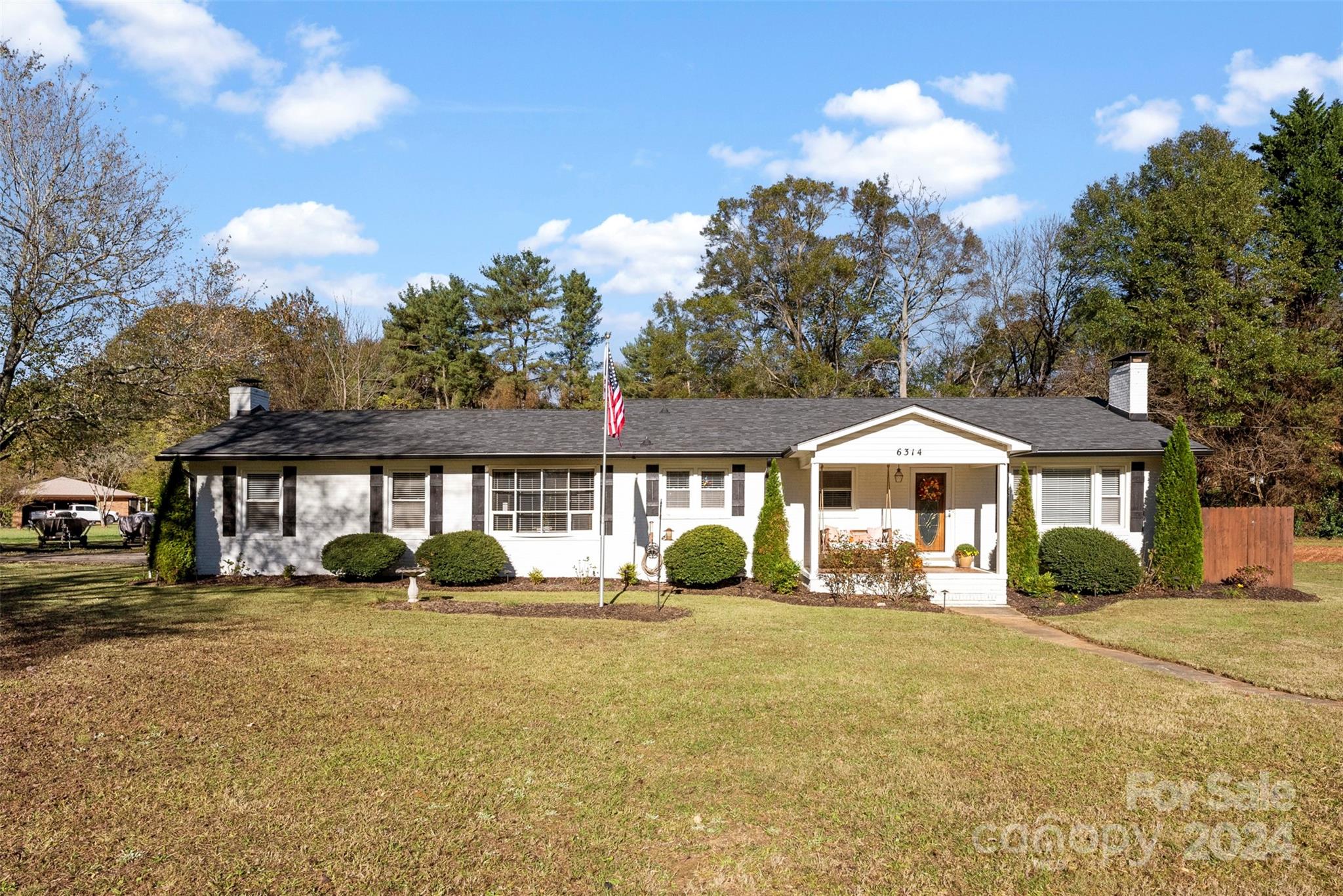 a front view of a house with a yard and trees