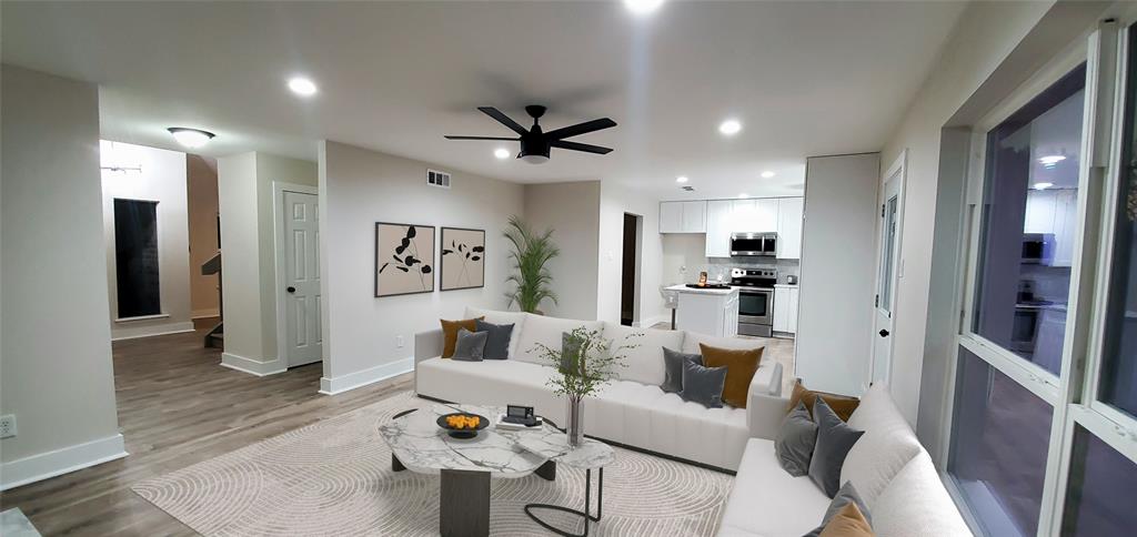 a living room with furniture and a wooden floor