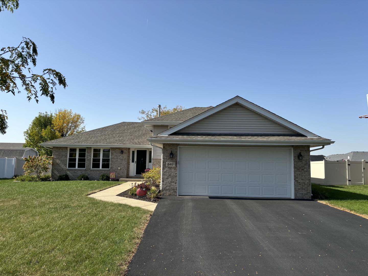 a front view of house with yard and trees in the background