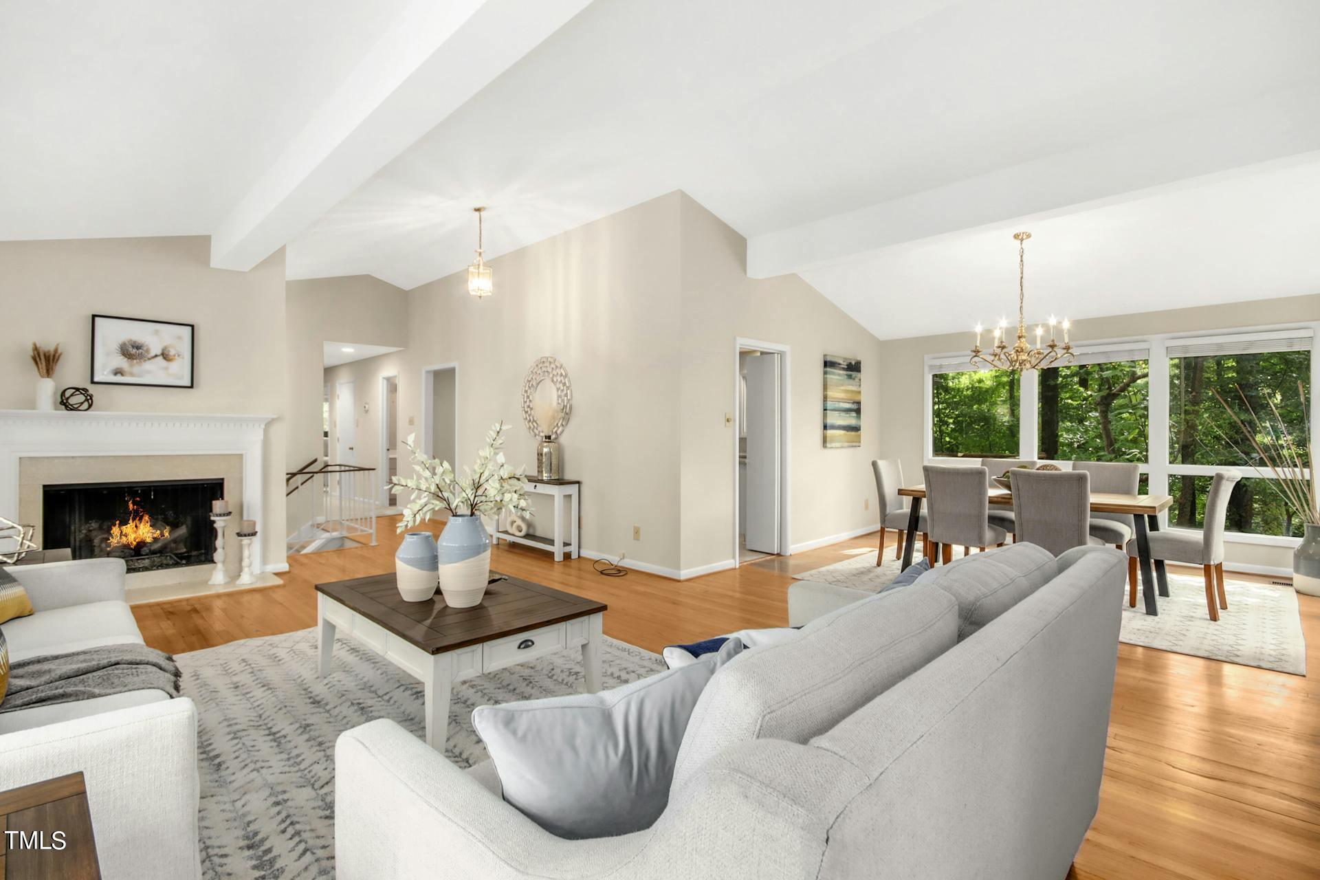 a living room with furniture a fireplace and a dining table with wooden floor