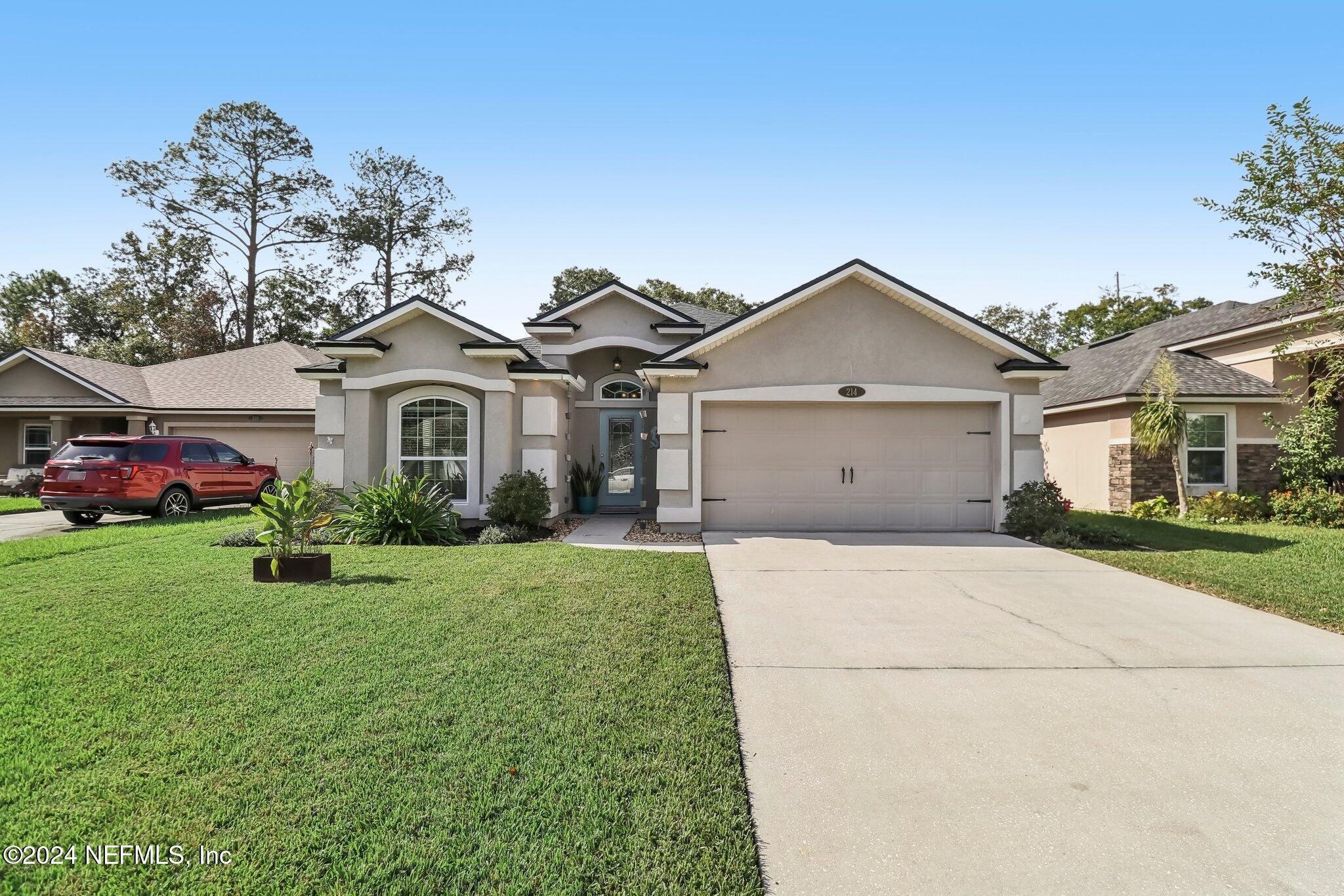 a front view of a house with a yard and garage