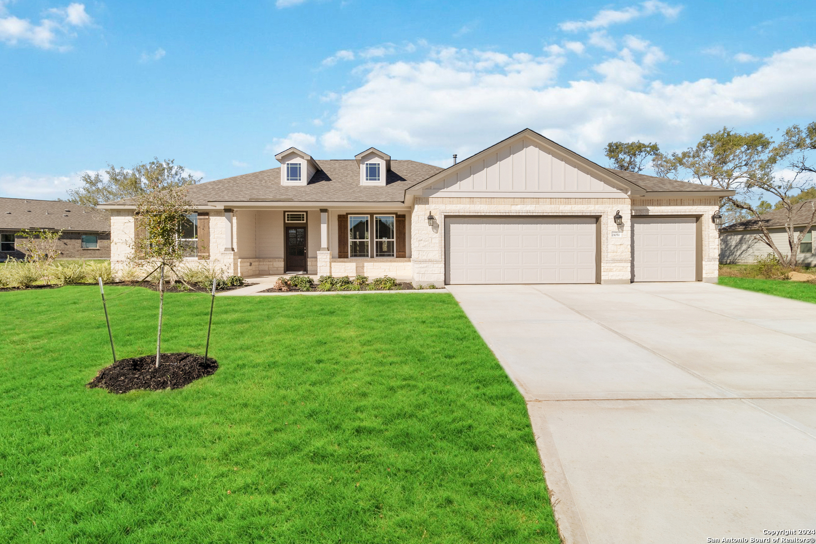 a front view of a house with a yard and trees