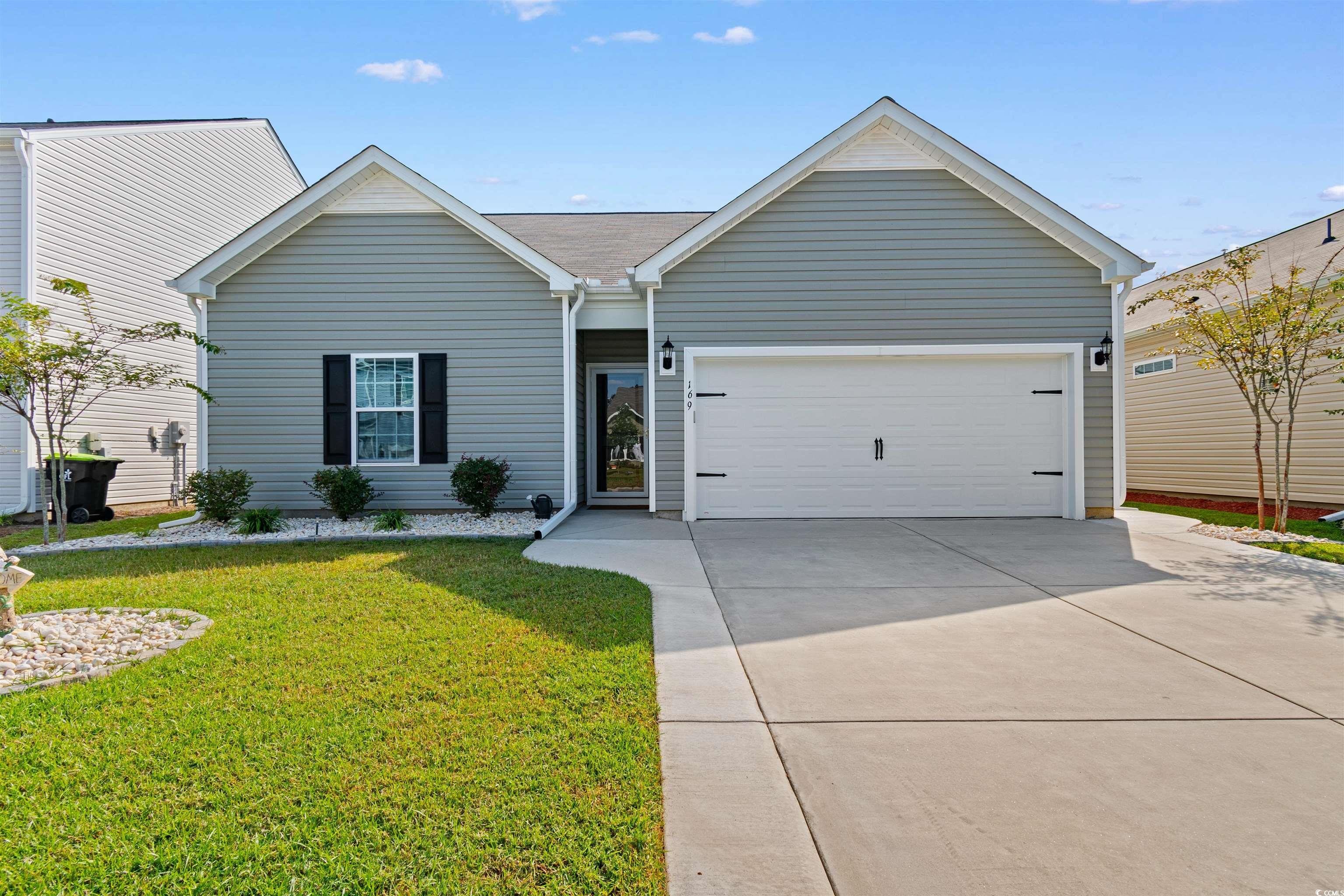 Ranch-style home featuring a garage and a front ya