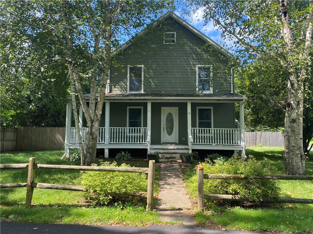 View of front facade featuring a front lawn and covered porch