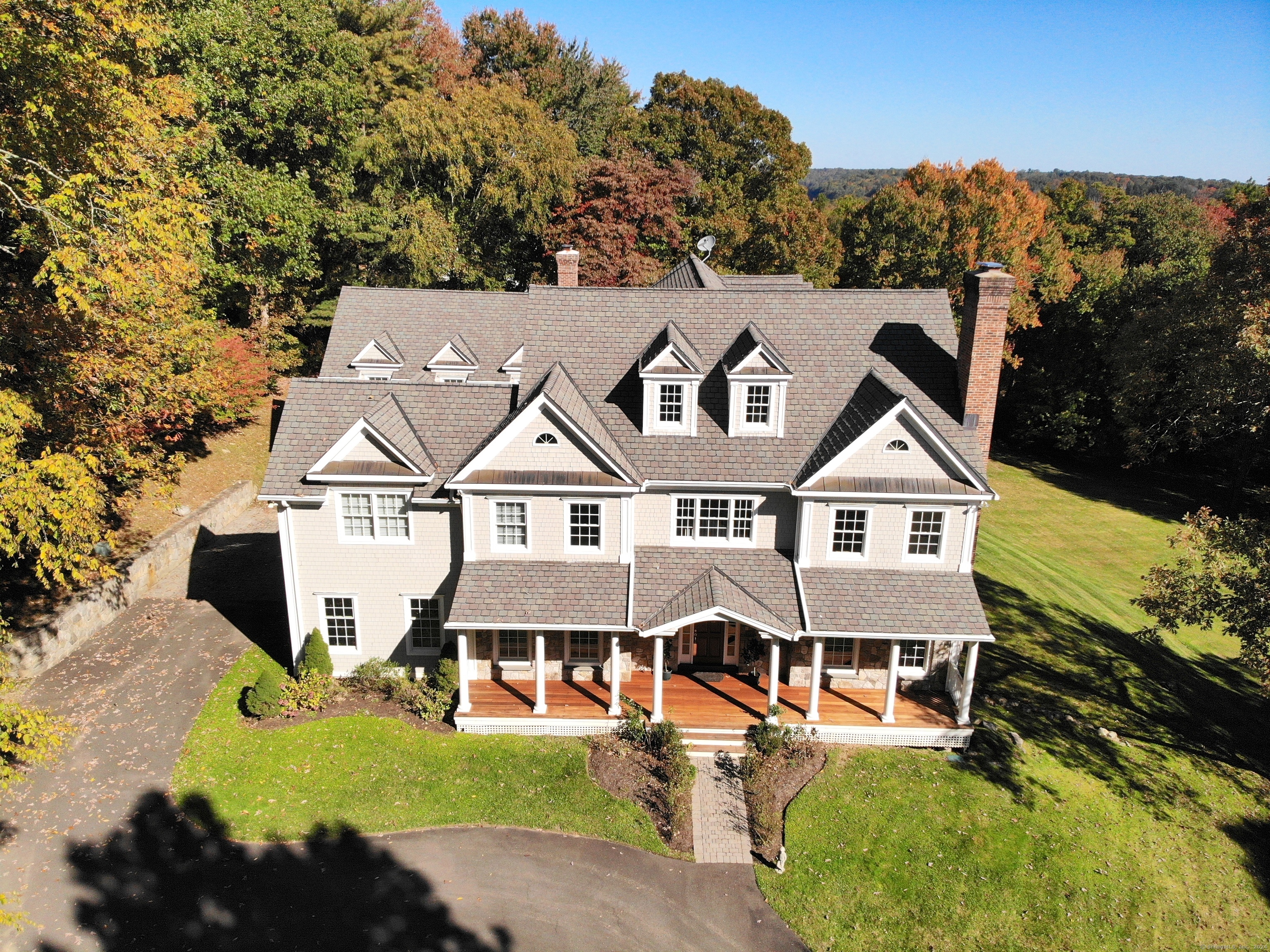 an aerial view of a house with swimming pool and mountains in the background