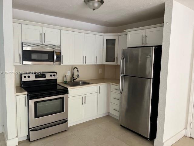 a kitchen with stainless steel appliances white cabinets and a refrigerator