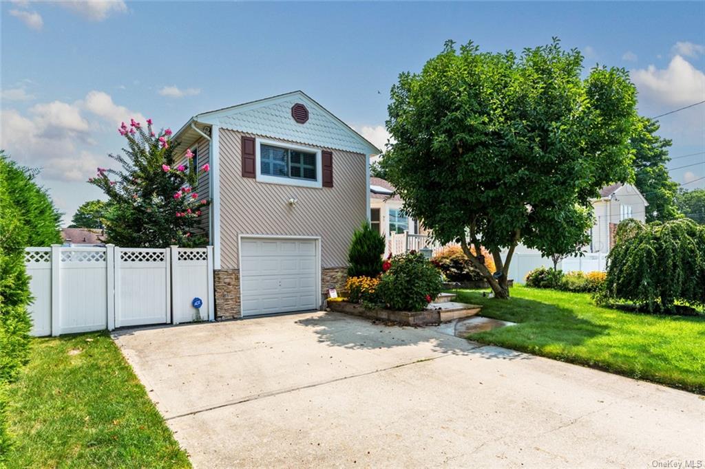 View of front of house featuring a front lawn and a garage