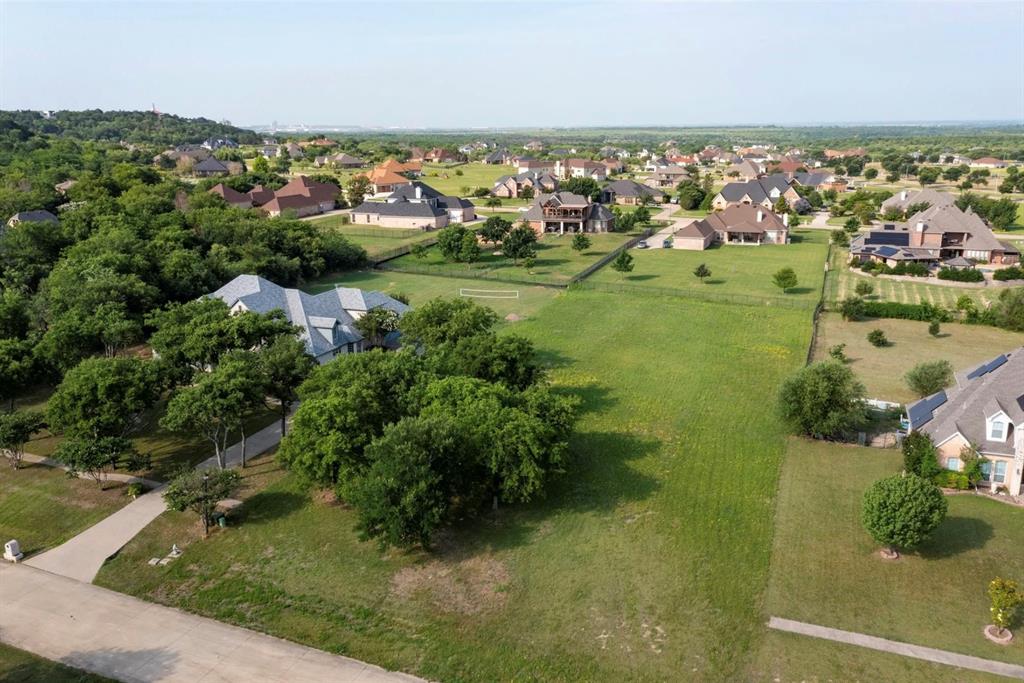 an aerial view of residential houses with outdoor space and trees