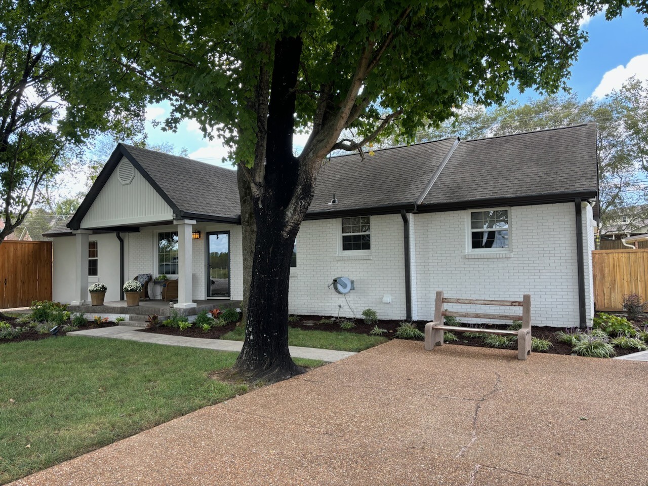 a front view of a house with a garden and trees