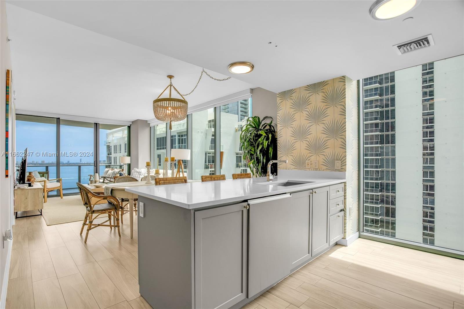 a kitchen with counter top space sink and living room view