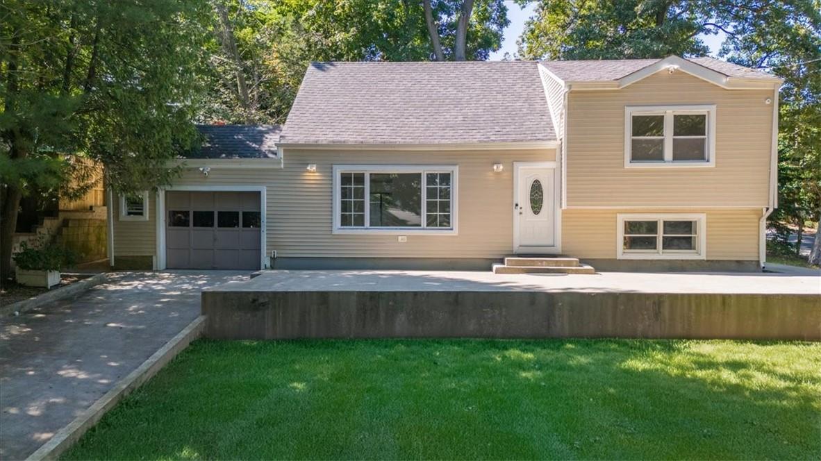 View of front of property featuring a garage and a front yard