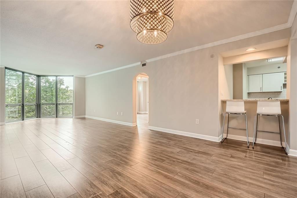 a view of an empty room with glass door and windows