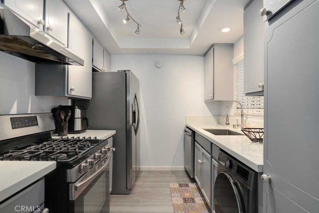 a kitchen with stainless steel appliances granite countertop a sink stove and refrigerator