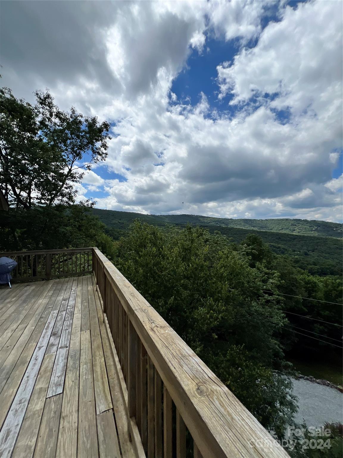 a view of balcony with wooden floor and fence