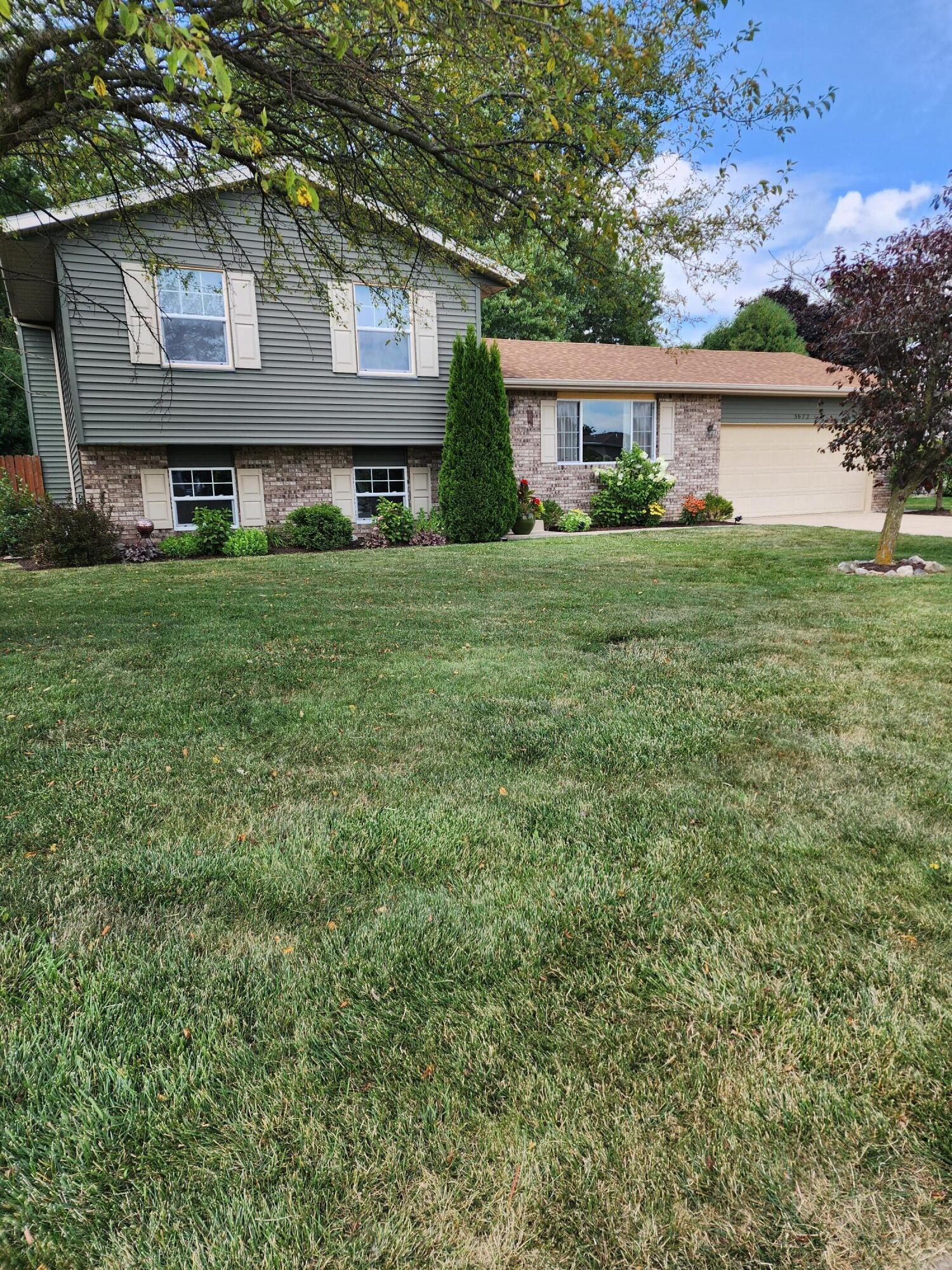 a front view of a house with a yard and trees