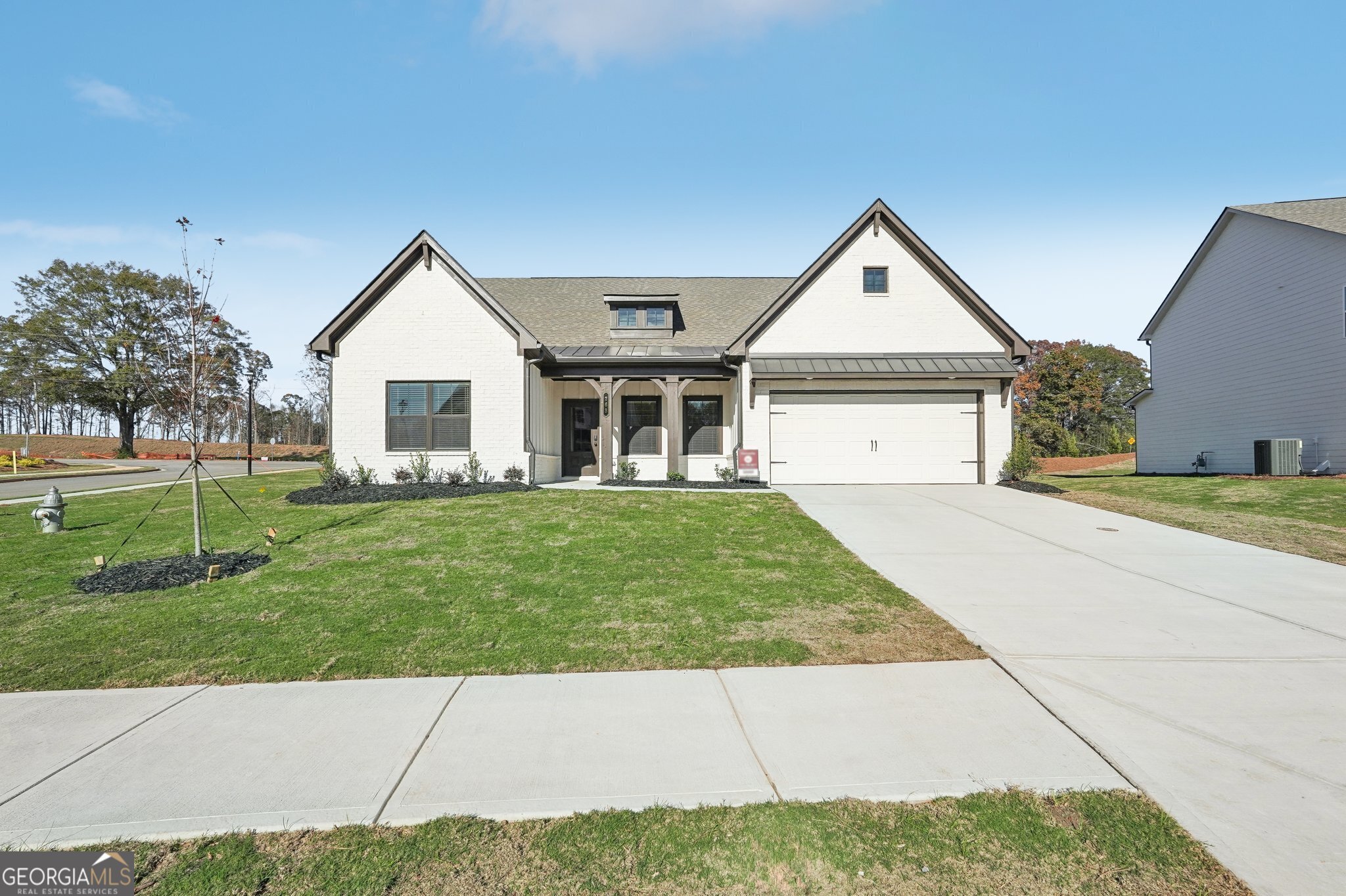 a front view of a house with a garden and yard