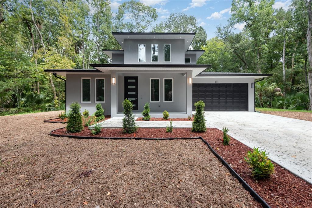 a front view of a house with porch and garden