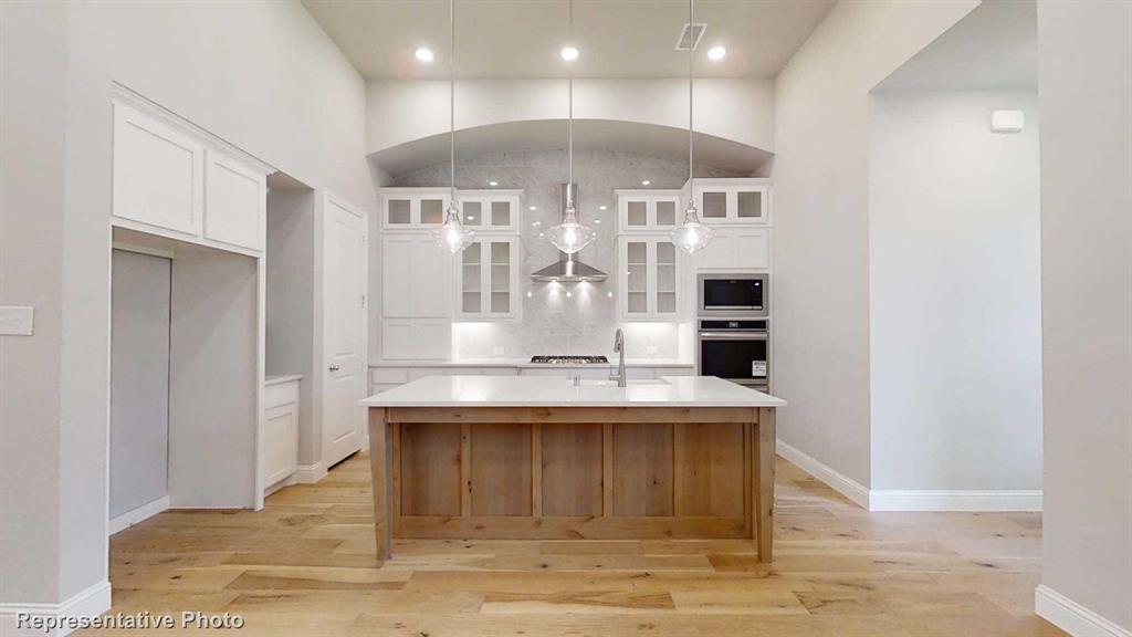 a view of a kitchen with kitchen island stainless steel appliances wooden floor and cabinets