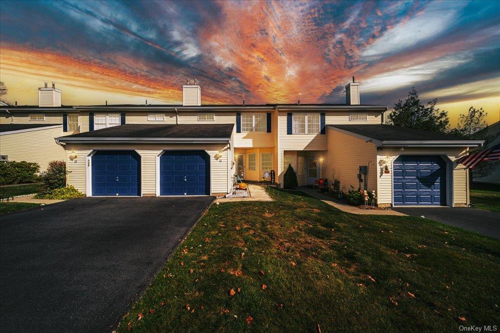 View of front facade with a garage and a yard