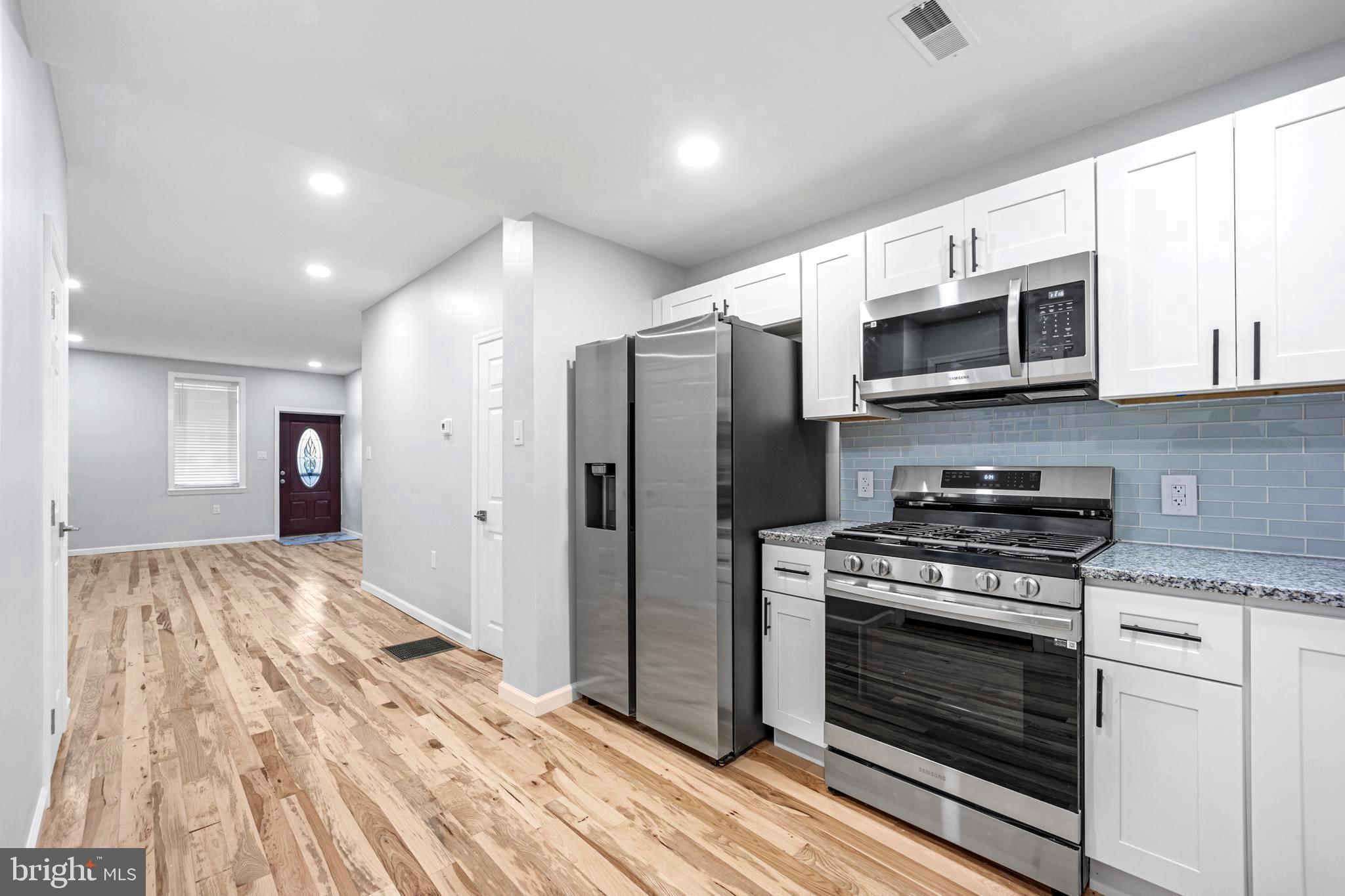 a kitchen with stainless steel appliances granite countertop a stove microwave and refrigerator