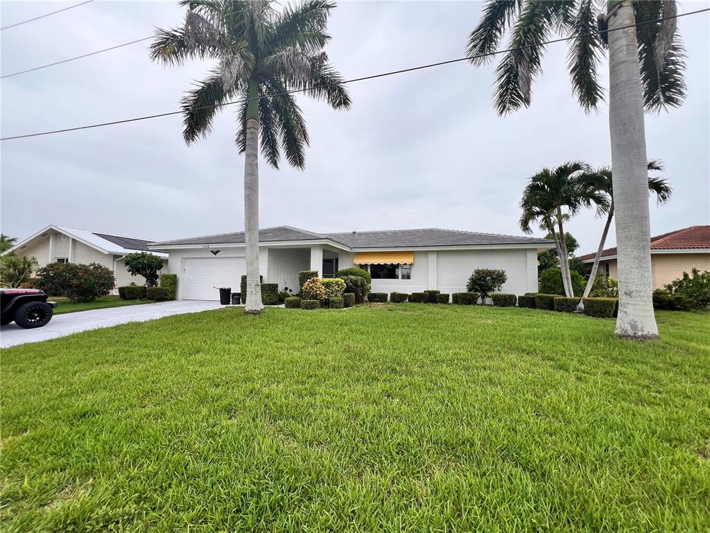 a front view of a house with garden and parking space