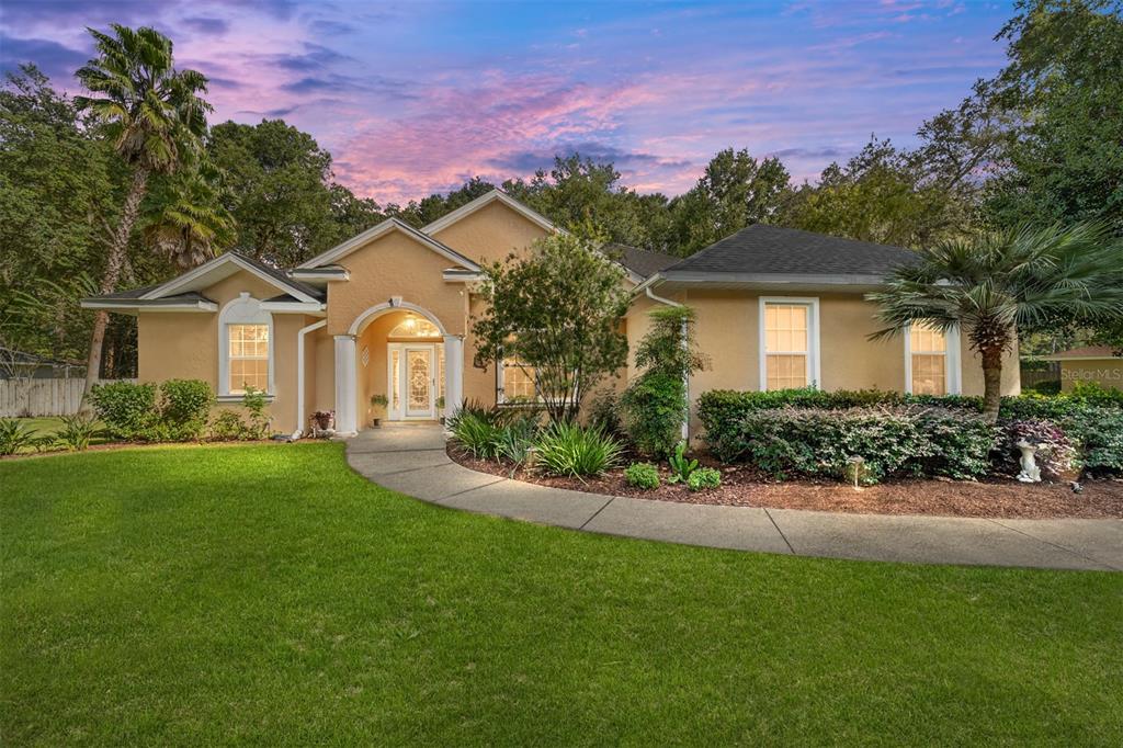 a front view of a house with a garden