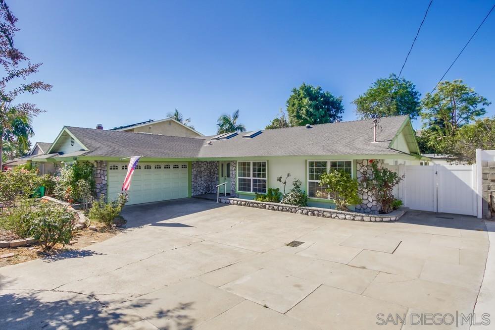 a view of a house with a yard and potted plants