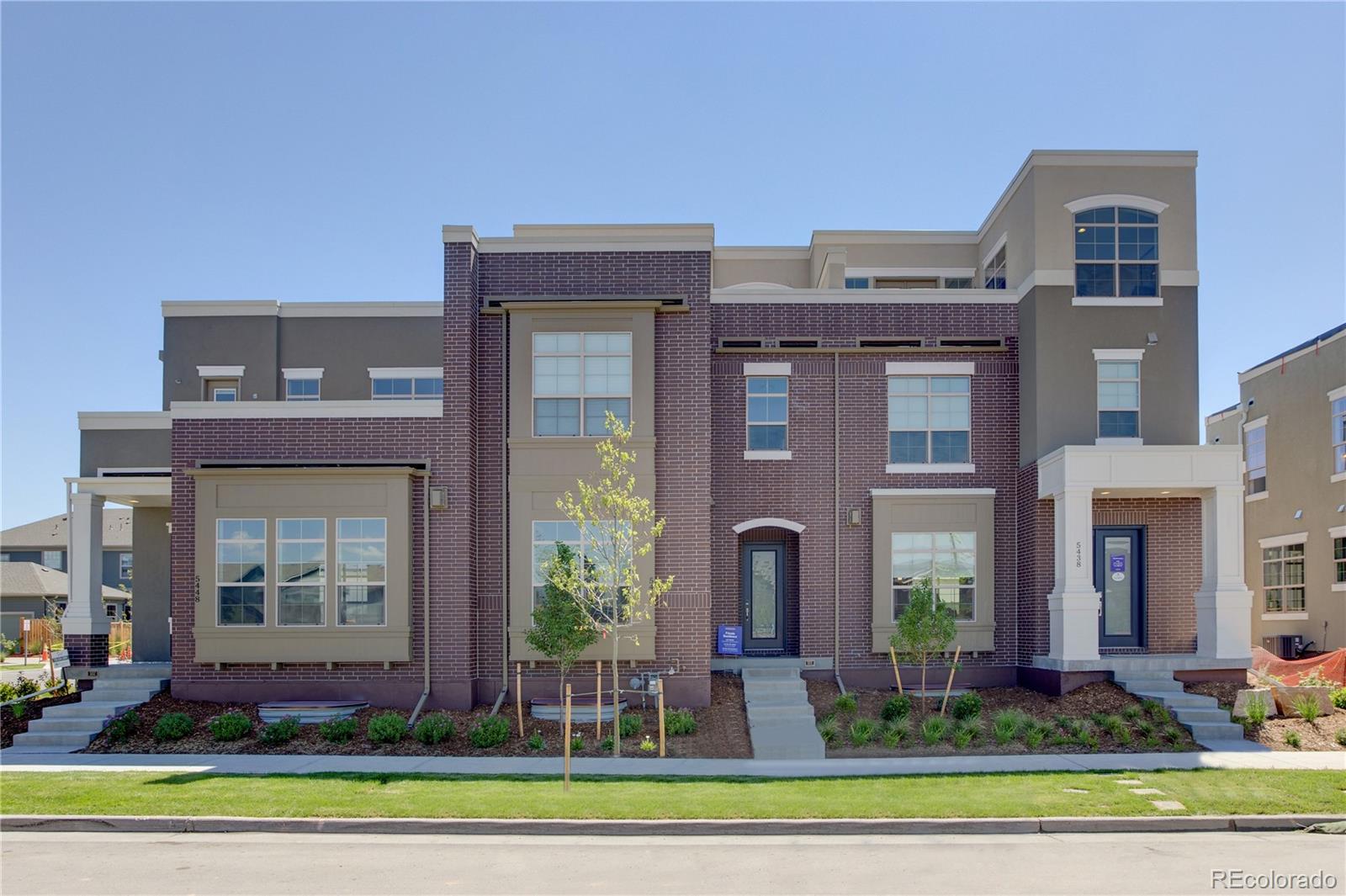 a front view of a brick house with a yard