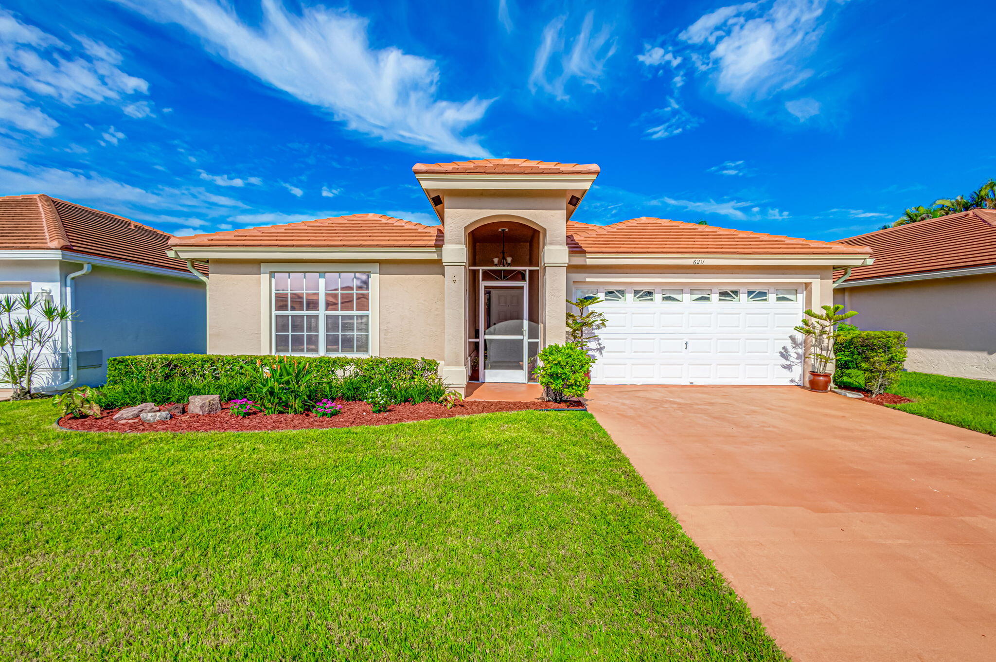 a front view of a house with a garden