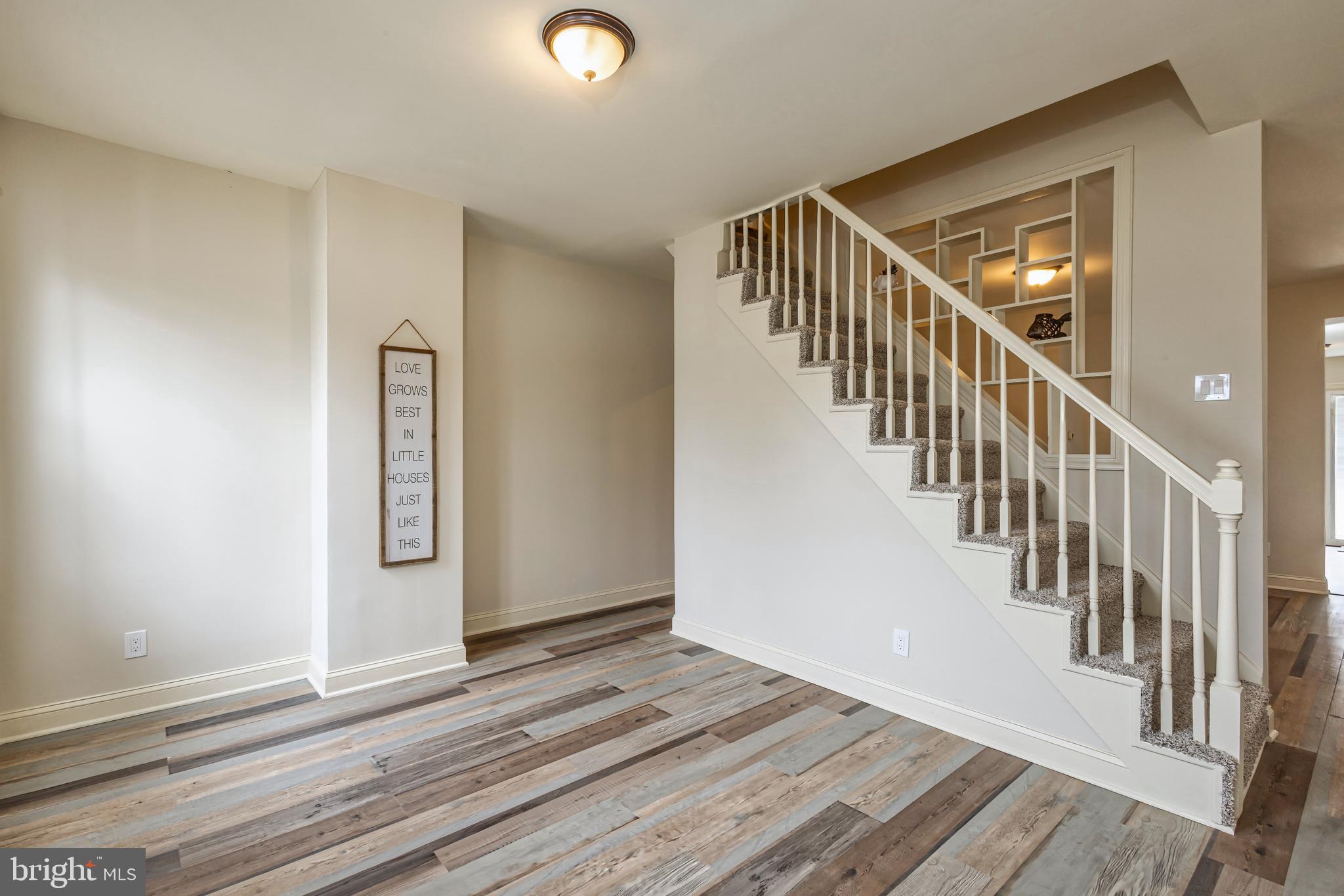 a view of a hallway with wooden floor and staircase