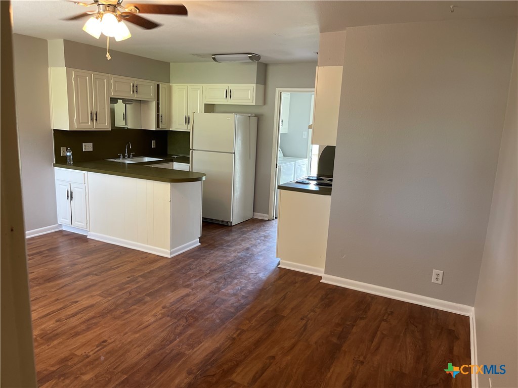 a kitchen with granite countertop a refrigerator and a stove top oven