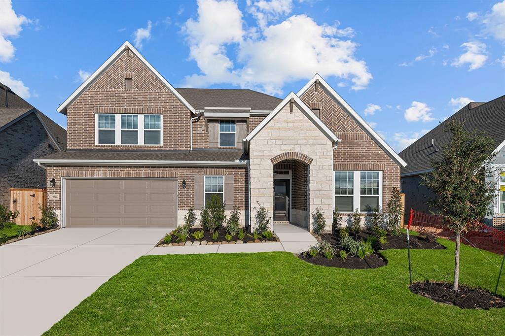 a front view of a house with a yard and garage