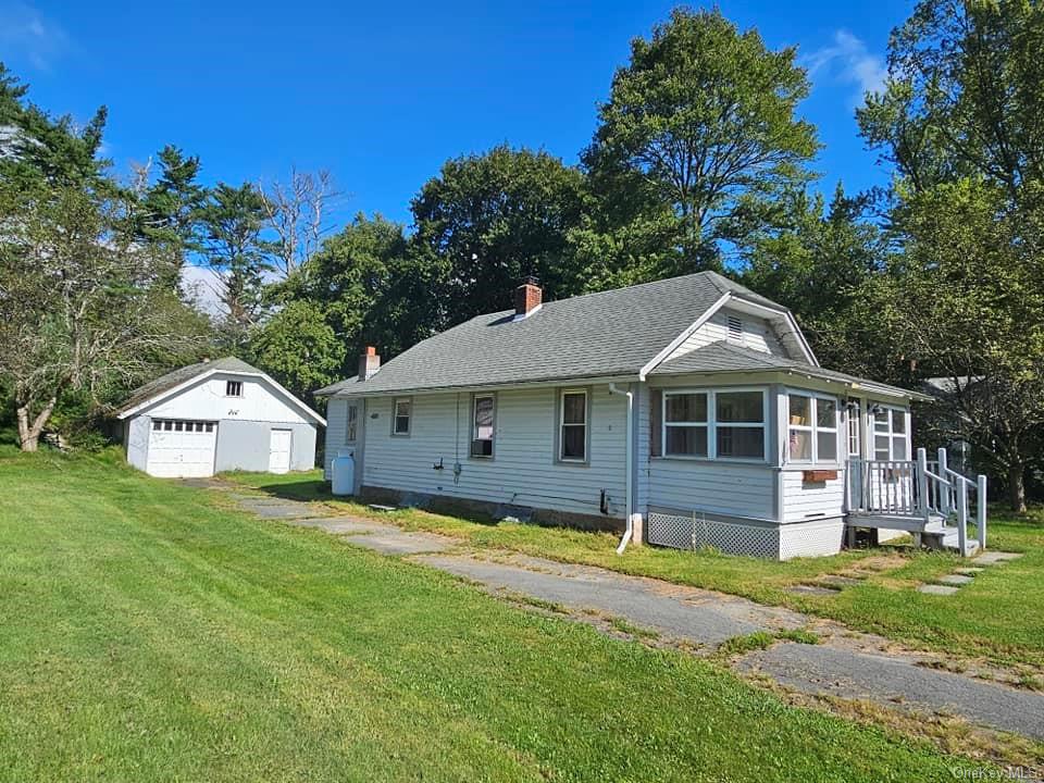 a front view of a house with a yard and trees