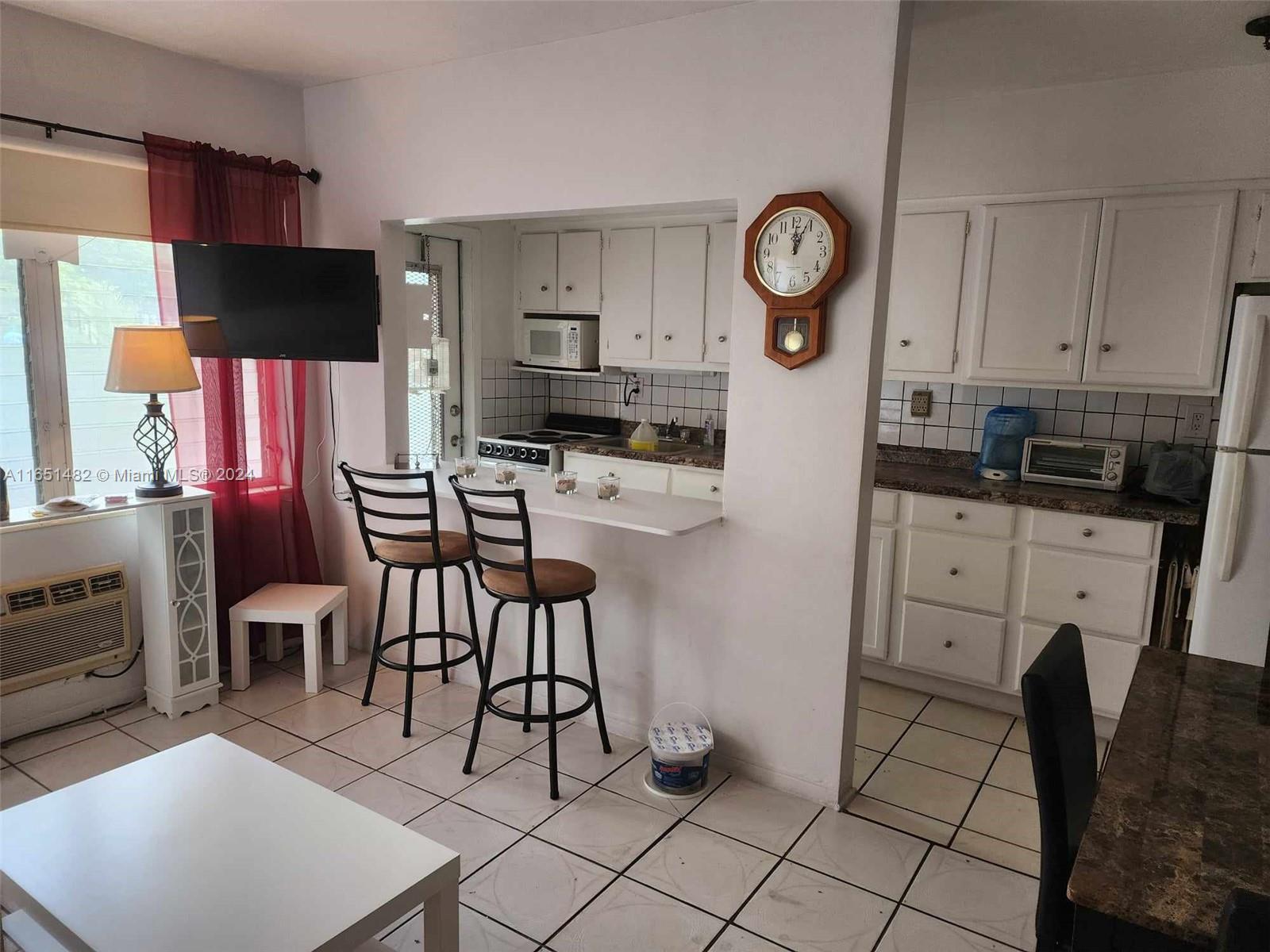 a very nice looking open kitchen with stainless steel appliances granite countertop a stove a refrigerator a dining table and chairs