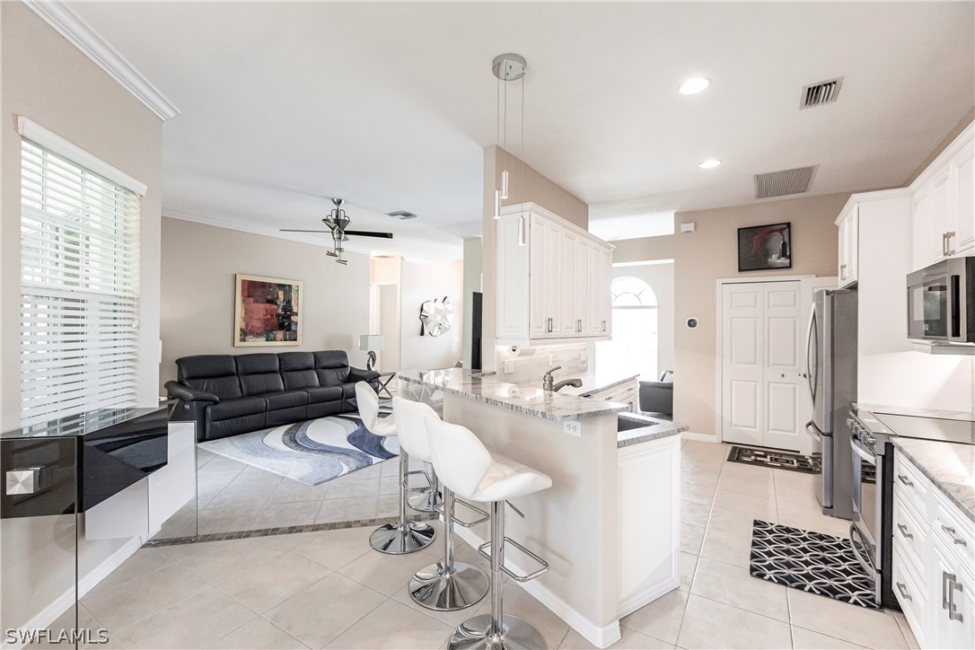 a living room with stainless steel appliances kitchen island granite countertop furniture and a view of kitchen