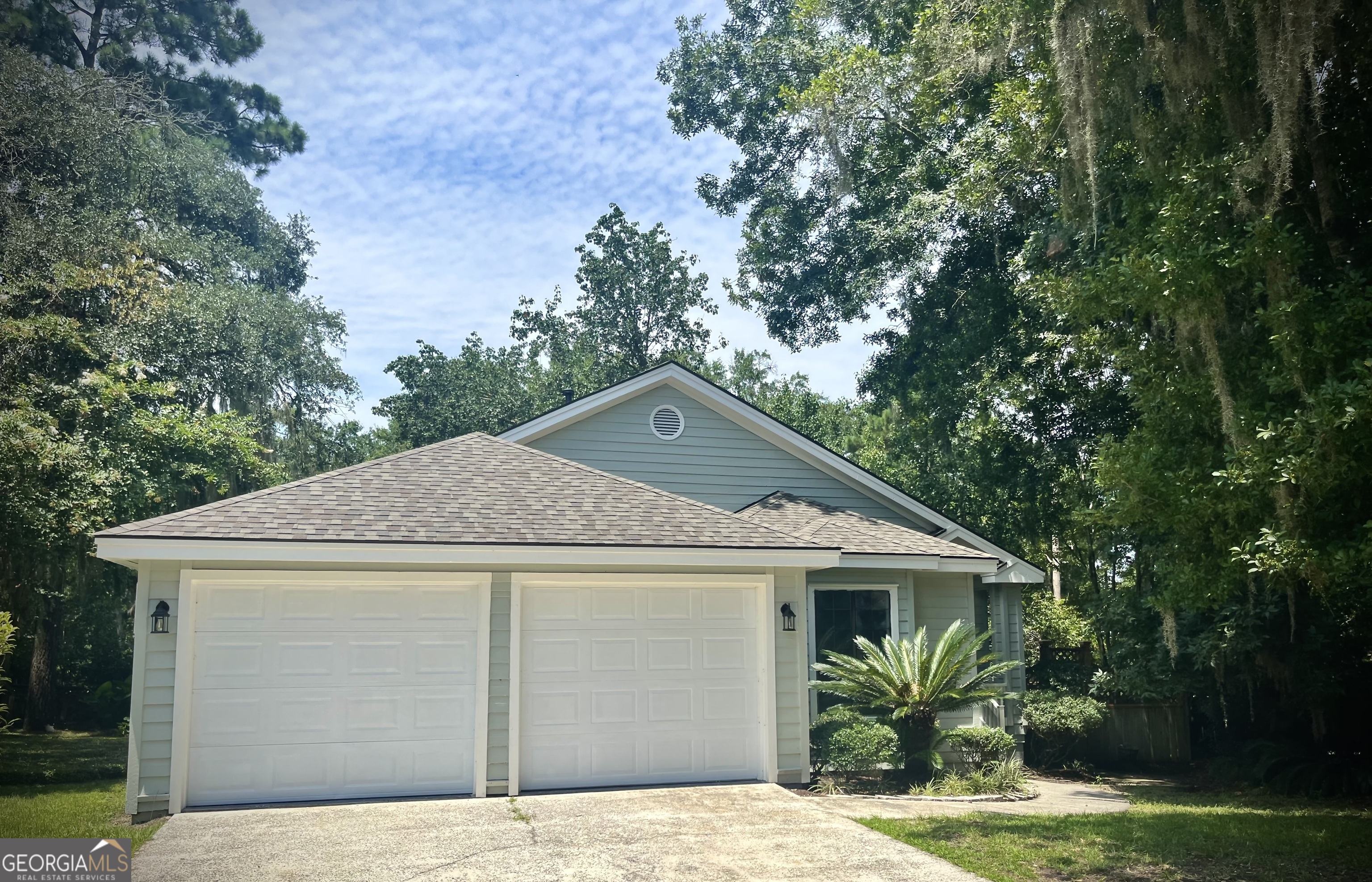 a front view of a house with a garden and plants