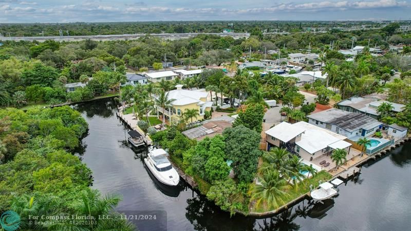 an aerial view of residential houses with outdoor space and trees