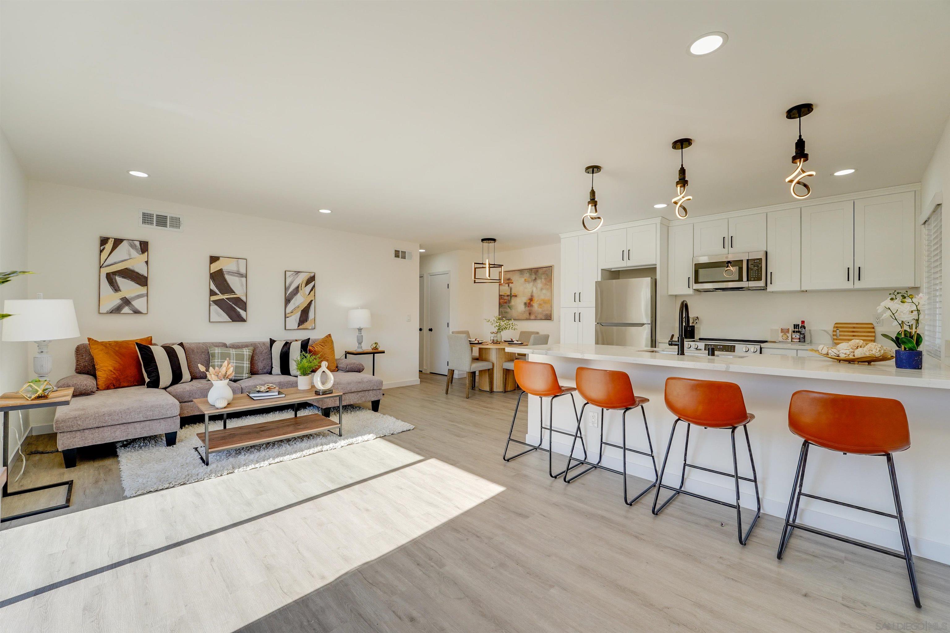 a living room with lots of furniture and kitchen view